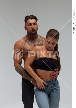 Woman hugging muscular man from behind 73618059