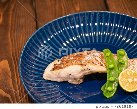 こんがり焼いた鯛の切り身。スナップエンドウとすだちをトッピング。 73619187