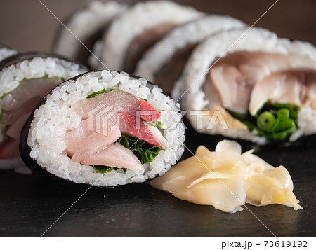 ブリを海苔と酢飯で巻いた鰤の巻き寿司のクローズアップ。 ブリを海苔と酢飯で巻いた鰤の巻き寿司のクローズアップ。 73619192