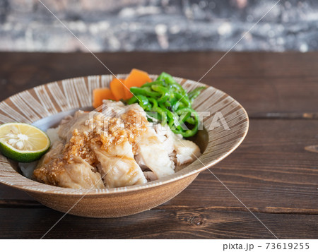 ご飯の上に乗せた鶏肉の料理、タレの付いたカオマンガイ。 73619255