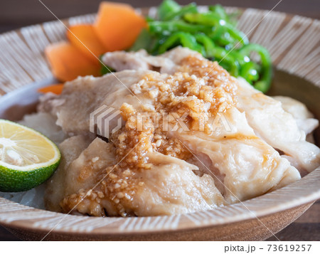 ご飯の上に乗せた鶏肉の料理、タレの付いたカオマンガイ。 73619257