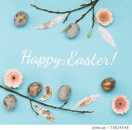 Easter Decoration with gray golden eggs, quail feathers, flowers on blue background. Happy Easter card concept, top view. Easter Decoration with gray golden eggs, quail feathers, flowers on blue background. Happy Easter card concept, top view. 73624548