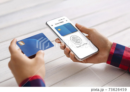 Guy Using Phone And Credit Card Paying With E-Wallet Indoors 73626459