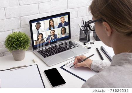 Female Taking Notes Sitting At Laptop Having Video Call Indoors Female Taking Notes Sitting At Laptop Having Video Call Indoors 73626552