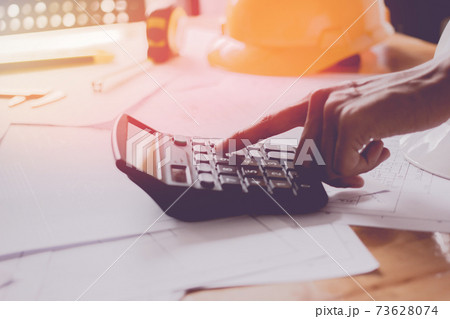 Close up man hand using calculator Calculating bonus(Or other compensation) to employees to increase productivity. 73628074