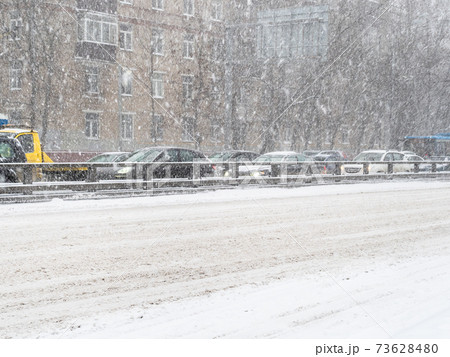 snow-covered urban road in snowfall 73628480