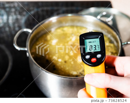 measuring temperature of hot soup by thermometer 73628524