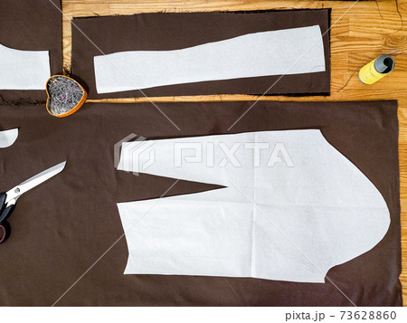 view of paper layouts of pattern on brown fabric 73628860
