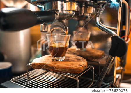 Espresso coffee is flowing into the shot cup. 73629073