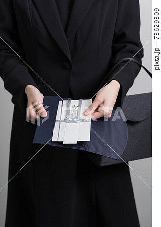 香典を渡す若い女性の手 【葬儀】 香典を渡す若い女性の手 【葬儀】 73629309