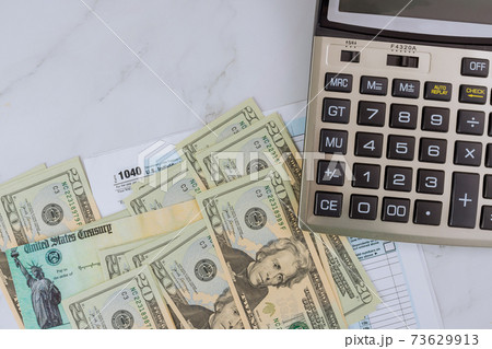 Individual Income Tax return form 1040 U.S. with calculator on US american dollars Individual Income Tax return form 1040 U.S. with calculator on US american dollars 73629913