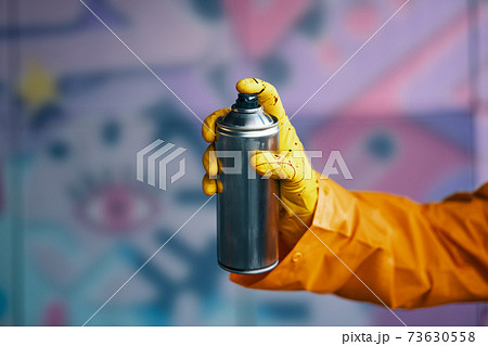 Graffiti artist pointing spray paint can to camera 73630558