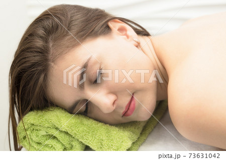 Young woman resting in a massage parlor, put her head on a towel 73631042