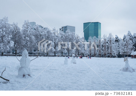 Intense snowfall in Zurich, Switzerland: Snowmen in the park Josefwiese 73632181