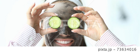 Laughing woman with a cosmetic mask on her face Laughing woman with a cosmetic mask on her face 73634016