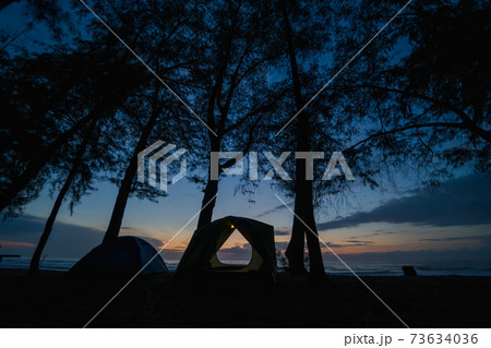 silhouette camping tent on beach with sunrise and sea background silhouette camping tent on beach with sunrise and sea background 73634036