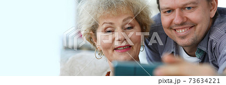 Adult son shows mother a photo in the phone Adult son shows mother a photo in the phone 73634221