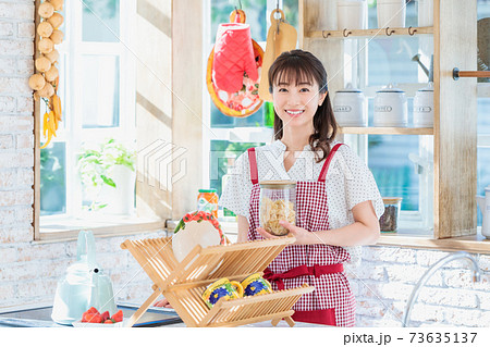 キッチンでパスタ料理を作る若い女性 73635137