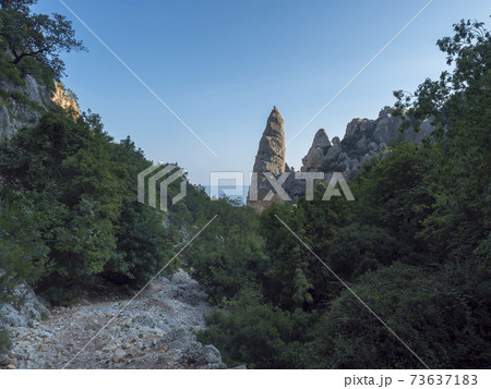 A view of valley with rocky hiking path c beach, limestone rocks and sea. Famous travel destination. Gulf of Orosei, Sardinia, Italy, September A view of valley with rocky hiking path c beach, limestone rocks and sea. Famous travel destination. Gulf of Orosei, Sardinia, Italy, September 73637183