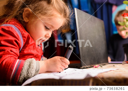 Preschool girl learns to draw a circle, black circles on a white sheet of paper, happy child. 73638261