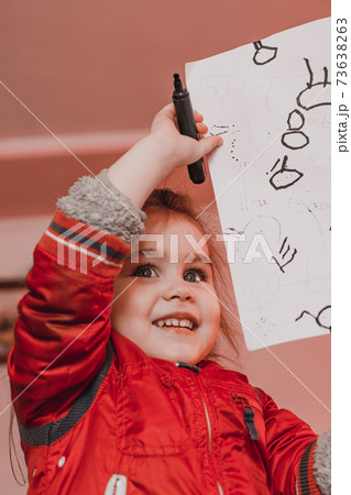 Preschool girl learns to draw a circle, black circles on a white sheet of paper, happy child. 73638263