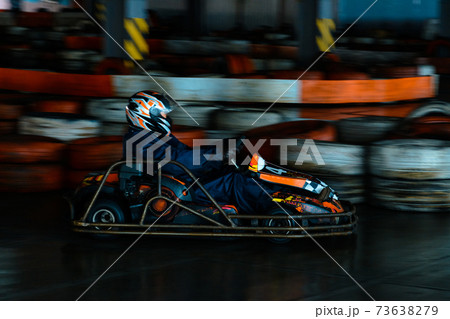 Dynamic karting competition at speed with blurry motion on an equipped racecourse Dynamic karting competition at speed with blurry motion on an equipped racecourse 73638279