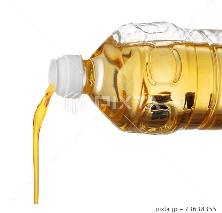 Pouring oil for cooking in a bottle isolated on white background. 73638355