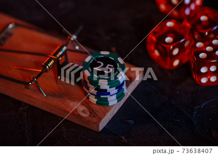Mousetrap and casino chips on a grey background. Close-up Mousetrap and casino chips on a grey background. Close-up 73638407