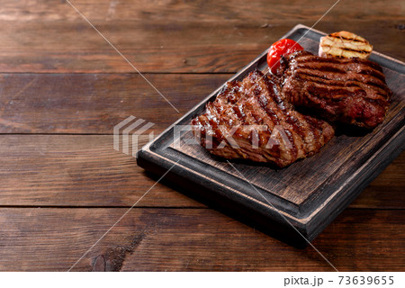 Fresh juicy delicious beef steak on a dark background Fresh juicy delicious beef steak on a dark background 73639655