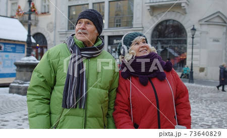 Elderly senior man woman tourists talking, gesturing in old city, holidays vacation trip concept Elderly senior man woman tourists talking, gesturing in old city, holidays vacation trip concept 73640829