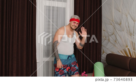Sportsman retro guy in funny sport clothes waving greeting with hand hello or bye, showing thumbs up 73640893