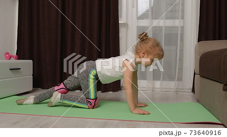 Child kid training gymnastics stretching at home, children girl making sport workout exercises 73640916