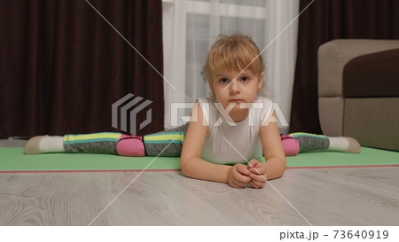 Child kid training gymnastics stretching twine at home, children girl making sport workout exercises Child kid training gymnastics stretching twine at home, children girl making sport workout exercises 73640919