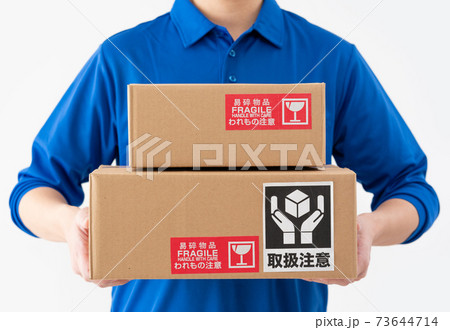 荷物を持つ白背景の宅配便の男性の手元のアップ 73644714