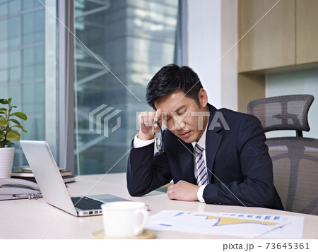 asian businessman woking in office looking tired or frustrated asian businessman woking in office looking tired or frustrated 73645361