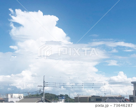 夏の入道雲と電線の連なる街並みの風景 73646287