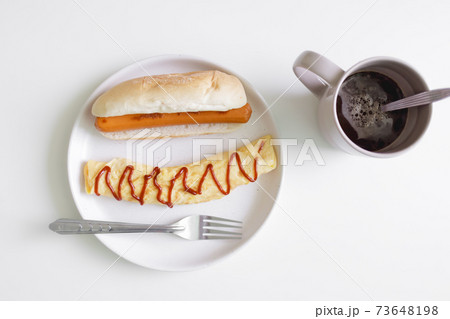 Simple easy breakfast of omelette and sausage served on white table. Simple easy breakfast of omelette and sausage served on white table. 73648198