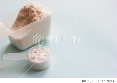 Fish collagen peptides powder on blue background. Fish collagen peptides powder on blue background. 73649643