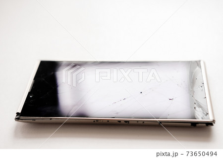 smartphone with broken screen. crackles on phone glass. crashed gadget. 73650494