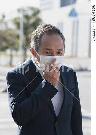 マスクをつけたスーツの60代日本人男性　 73654156