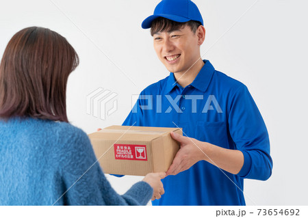 荷物を手渡す白背景の笑顔の宅配便の男性 荷物を手渡す白背景の笑顔の宅配便の男性 73654692