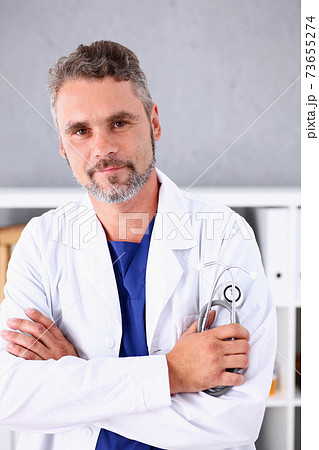 Handsome mature smiling male doctor with arms crossed on chest 73655274