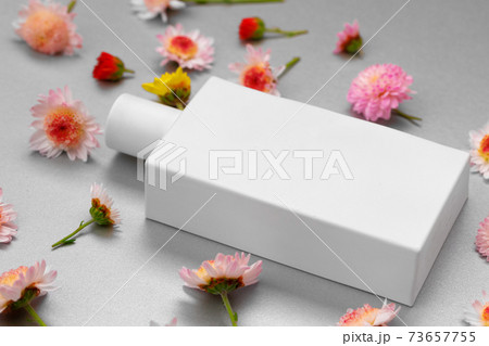 Bottle of fragrance surrounded by flower buds Bottle of fragrance surrounded by flower buds 73657755