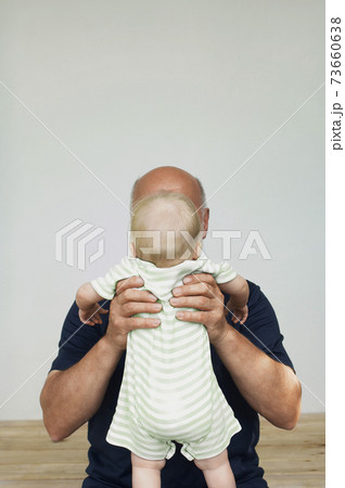 Grandfather Holding Up Grandchild 73660638
