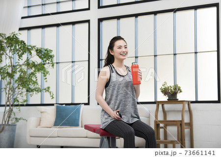 若い女性 ホームトレーニング 休憩 水分補給 若い女性 ホームトレーニング 休憩 水分補給 73661141