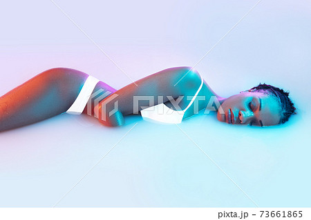 Beautiful female body in the milk bath with soft glowing in blue-pink neon light Beautiful female body in the milk bath with soft glowing in blue-pink neon light 73661865