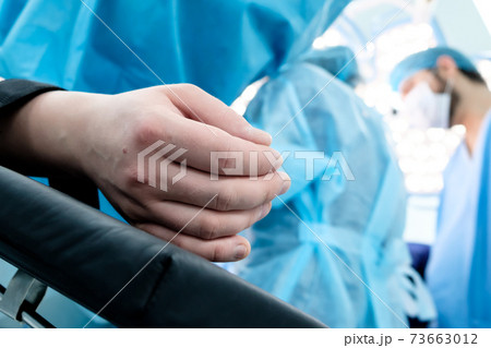 Hand of a patient lying on the operating table.  73663012