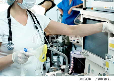 A doctor urgently prepares artificial lung ventilation equipment for a patient with a coronavirus 73663031
