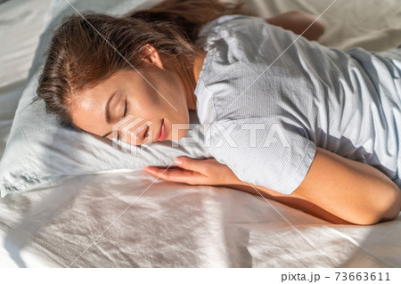 Bed Asian girl sleeping on stomach sleeper resting head on foam pillow 73663611
