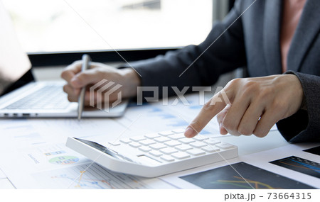 Financial businesswoman calculating corporate income tax data And analyzing charts of financial stocks that are in good condition with growth and progress, Investment in finance and accounting. 73664315